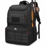 Open fishing tackle box backpack on a wooden dock by a calm lake