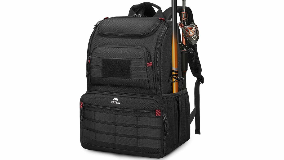 Open fishing tackle box backpack on a wooden dock by a calm lake