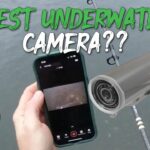 Waterproof action camera resting on a fishing boat gunwale at a calm lake